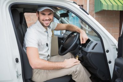 A delivery driving sitting the the driver's seat of his work vehicle