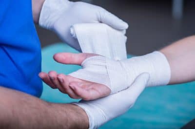 A doctor bandaging a patient's injured hand and wrist